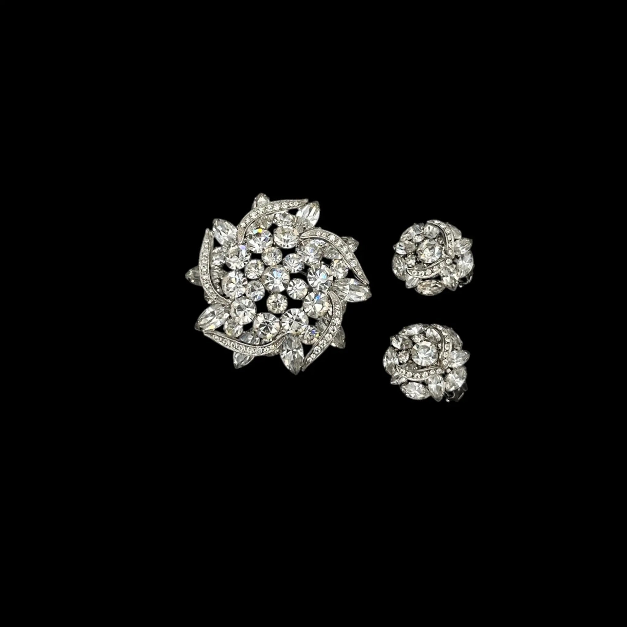 Against black background Weiss rhinestone brooch and earring set with vintage floral design