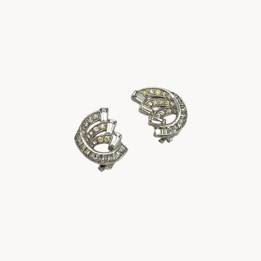 Side view of Weiss vintage clip-on rhinestone earrings with baguette and round stones in silver-tone setting.