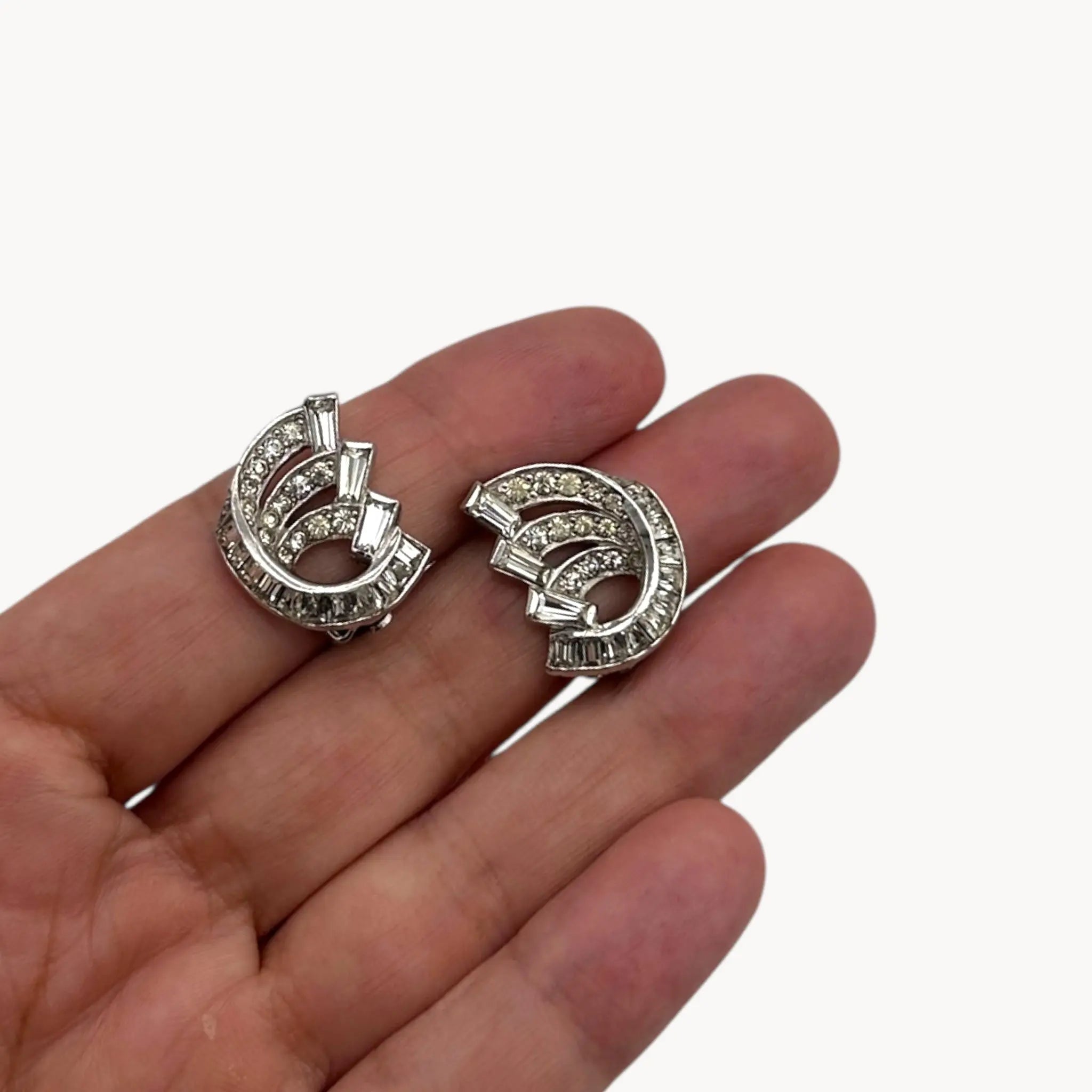 Scale picture of Weiss vintage clip-on rhinestone earrings with baguette and round stones in silver-tone setting.