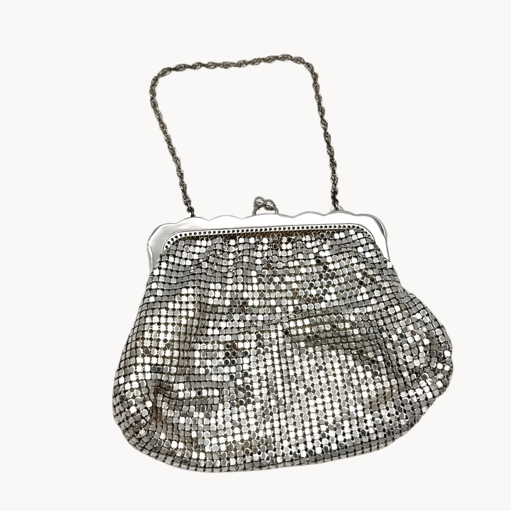 Close up view of Whiting & Davis silver mesh petite Art Deco style handbag with chain handle on white background.
