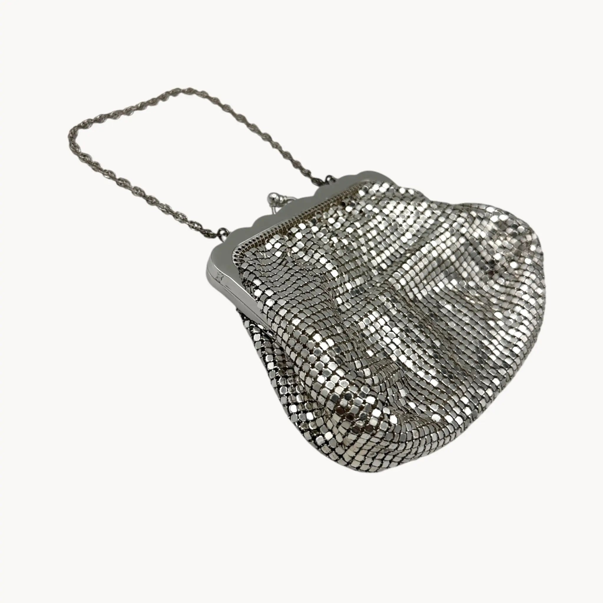 Side view of Whiting & Davis silver mesh petite Art Deco style handbag with chain handle on white background.