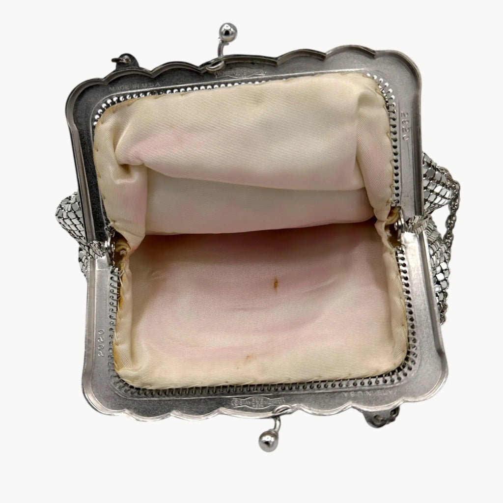 Open view of interior of Whiting & Davis silver mesh petite Art Deco style handbag with chain handle on white background.