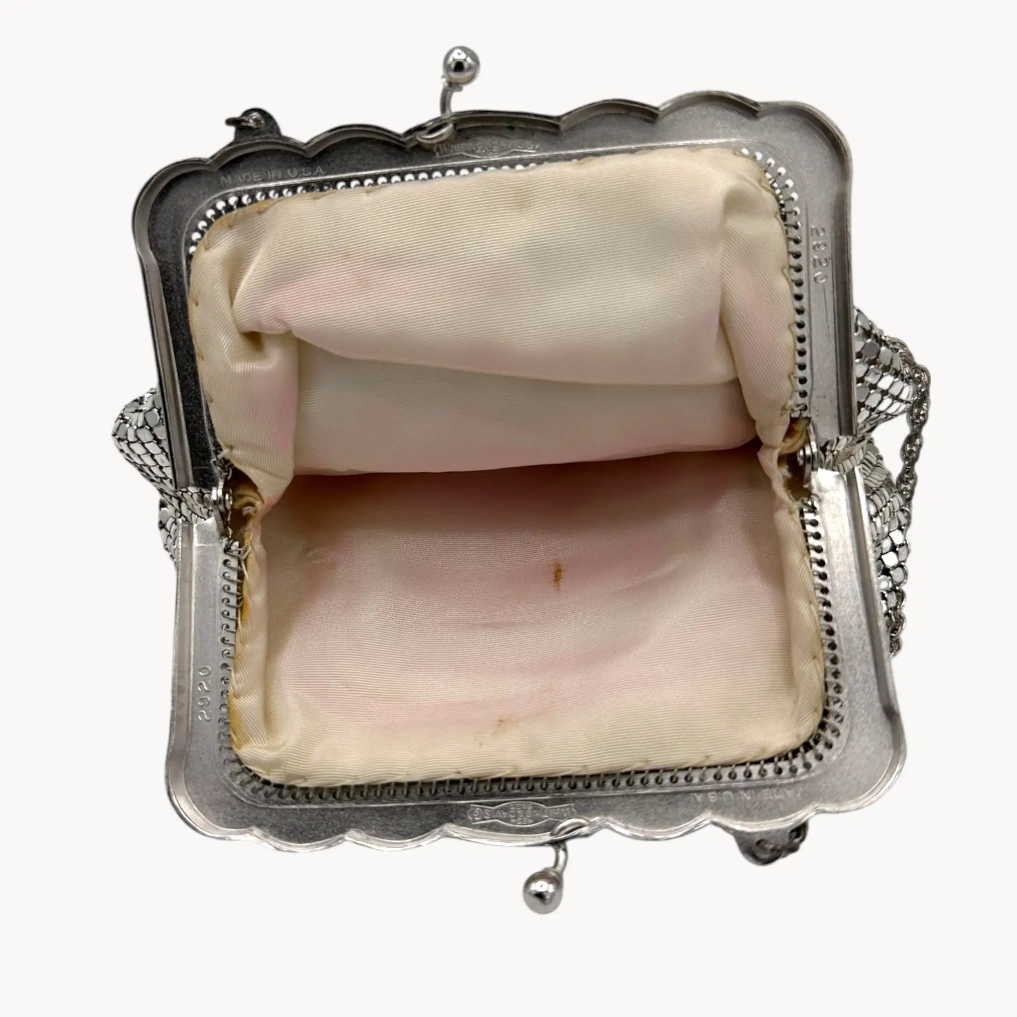 Open view of interior of Whiting & Davis silver mesh petite Art Deco style handbag with chain handle on white background.